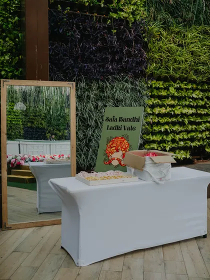A thoughtful corner at a wedding for the 'Ladki Wale' to tie their safas, set against a lush green wall, showing our attention to traditional details.