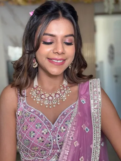 This shot highlights the beautiful pink tones in her makeup and outfit, which are complemented by the soft, romantic hairstyle.