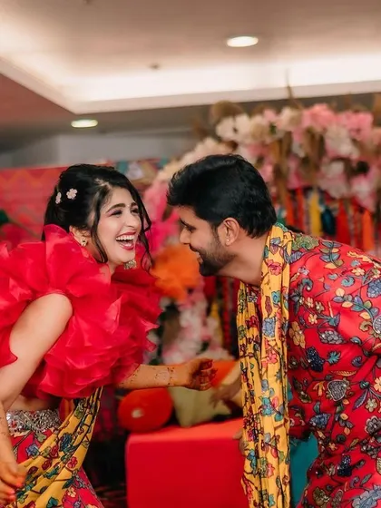 Fun and candid moments from a vibrant Mehendi event. The couple is sharing a laugh, surrounded by the bright, festive atmosphere I designed for their special day.