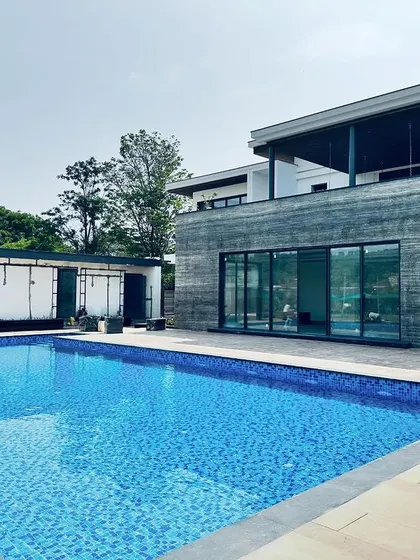The pool features built-in steps for easy access and is positioned to be a central feature of the home's outdoor space.