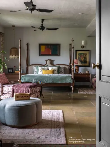 A magazine feature showcasing the master bedroom of the Dhaka residence. The photo captures the serene and cultured atmosphere we created with a four-poster bed, layered textiles, and curated art.