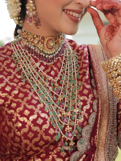 A close-up on the magnificent layered necklace and brocade blouse, key elements of this traditional bridal look.
