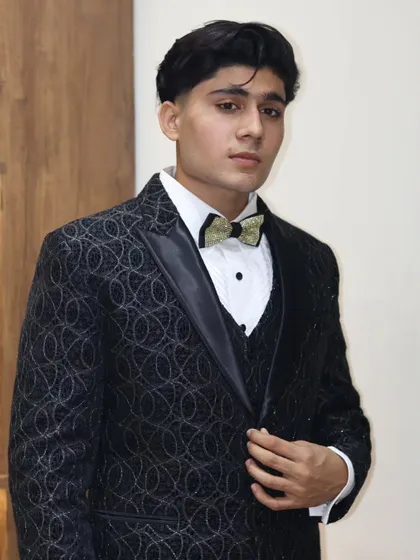 Another look at the black textured suit, showing how the light catches the pattern. It's a great choice for receptions and evening parties.