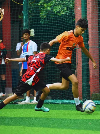 A player driving past a defender, showcasing the attacking skills we nurture at the academy.