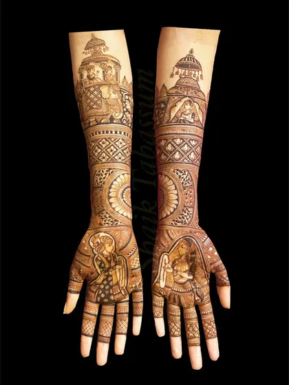 This regal design features portraits of the bride and groom in royal attire, with a groom on an elephant and a bride in a palanquin depicted on the forearms.