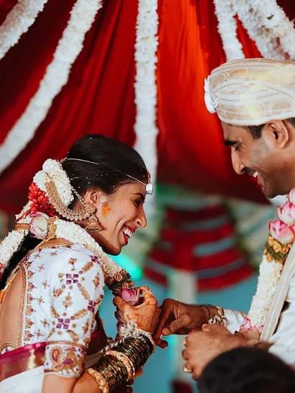 A joyful and candid moment between the bride and groom, their smiles lighting up the frame during the ceremony.