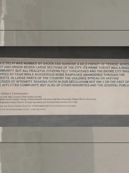 A plaque quoting The Citizen's Commission report on the 1984 violence. The inclusion of such external, formal reports within the memorial space is a strategy to legitimize the narrative of a targeted, organized massacre.
