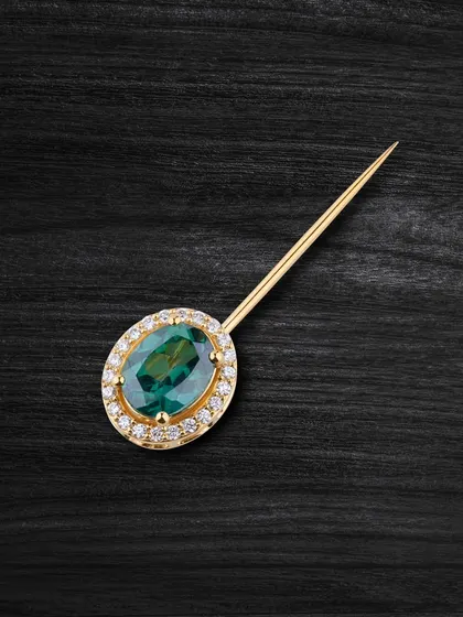 This captivating green topaz pin adds a touch of sophistication to any look. The halo of diamonds enhances its beautiful colour.