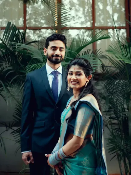 A formal portrait of a couple in a garden setting, capturing a moment of quiet elegance.