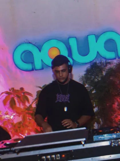 A cool shot of me DJing at an outdoor pool party. The "Aqua" sign and tropical plants give this a great summer vibe.