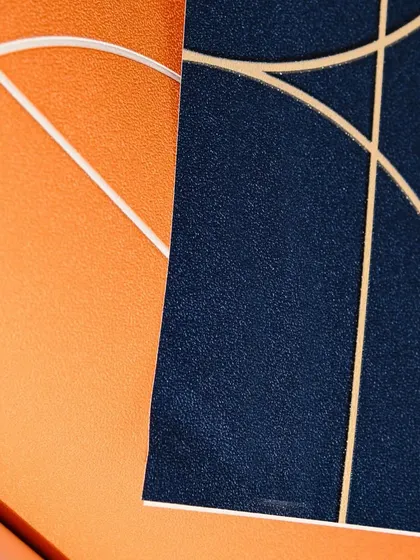 Dare to be bold with color. This image shows two vibrant wallpapers, a textured orange and a deep navy blue, both featuring clean, modern lines. These are perfect for creating an energetic and stylish space.