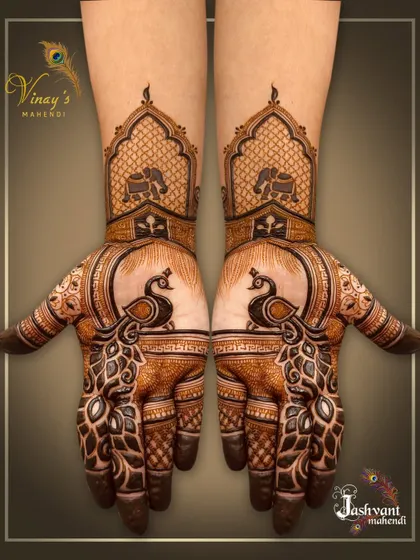 A classic peacock design where the bird's feathers form the main pattern on the palm. The design is complemented by elephant motifs on the wrist.
