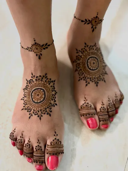 A minimal and chic feet design, featuring a central mandala on the top of the foot and a matching delicate anklet pattern.