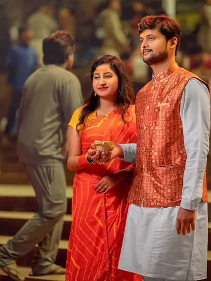 A moment of prayer and offering at the ghats. Dressed in vibrant traditional clothes, the couple's reverence and togetherness are the focus of this beautiful shot.