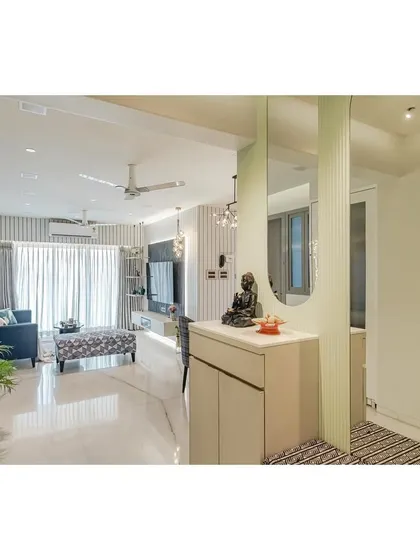 This perspective shows the entryway console with a Buddha statue, creating a peaceful transition into the main living area. The fluted glass partition subtly separates the spaces while allowing light to pass through, maintaining an open feel.