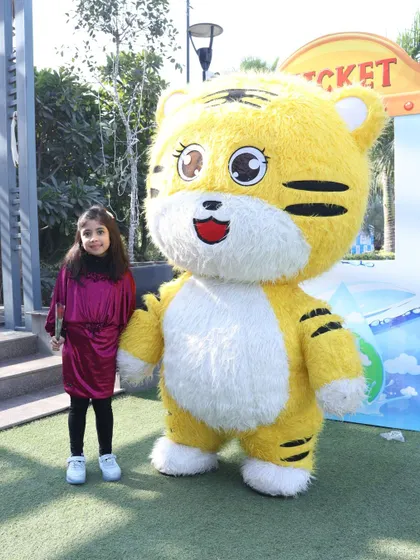 A young guest poses proudly next to our cheerful tiger mascot. Our performers are great at making every child feel special.