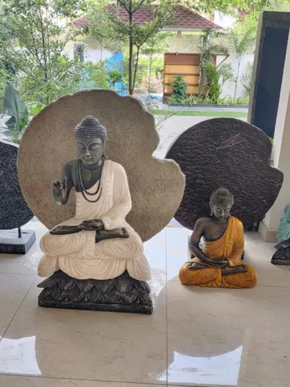A pair of beautiful Buddha statues in the Bali style, one in white and black, the other in yellow.