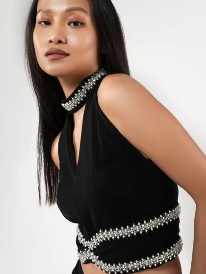 A close-up detail shot of a modern black top with pearl embellishments. This is essential for showcasing the quality and design of a garment.