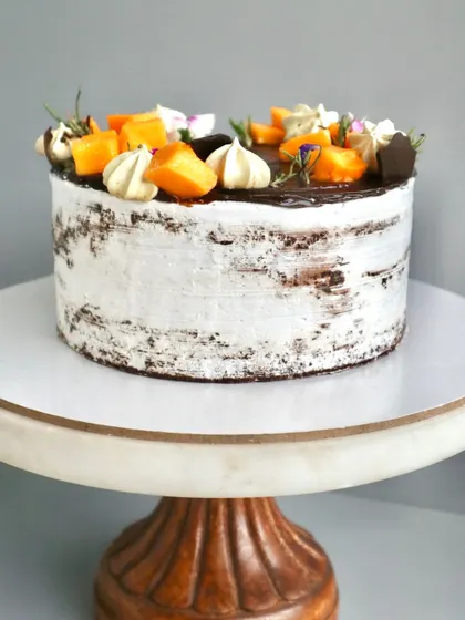 A side view of my Chocolate Mango Naked Cake, showing how the fresh mango chunks and light cream balance the rich chocolate sponge. It's a seasonal favourite.