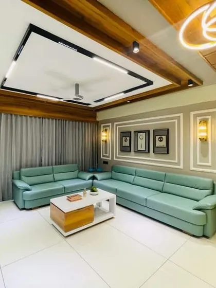 This living room combines a comfortable mint green sofa with warm wood ceiling panels and modern lighting. The result is a contemporary space that feels cozy and inviting.