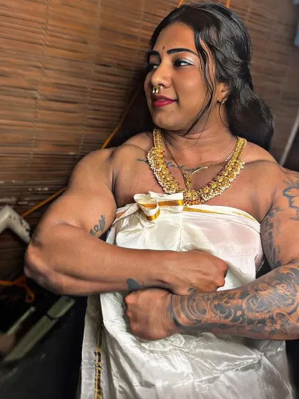 Every photo tells a story. Dressed in a traditional white and gold Kerala saree, this pose highlights my arm and shoulder muscles, telling a story of dedication.