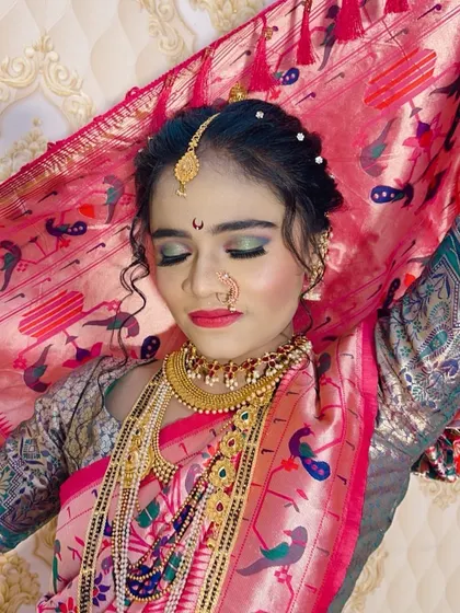 An artistic shot of the bride with her pink saree veil, highlighting the soft, glowing makeup.