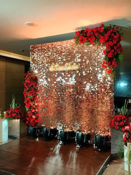 Another view of the glamorous anniversary backdrop with a red rose-framed sequin wall.