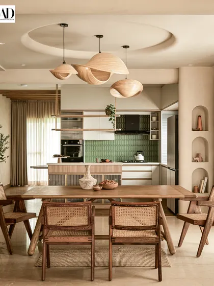 This shot from the AD feature shows the open dining and kitchen area. The design uses sculptural wooden pendant lights and cane chairs to create a cohesive, wabi-sabi inspired environment.
