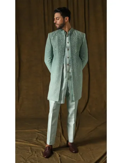 I designed this three-piece sherwani set in a refreshing mint green for a modern yet classic wedding look. The fully embroidered long jacket, paired with a matching inner kurta and trousers, is crafted from premium fabric to ensure both comfort and a commanding presence.