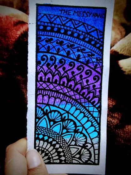 I turned a small, waste cut-out of watercolor paper into a vibrant mandala bookmark. The gradient of blue and purple was created with brush pens, showing that art can be made from anything.