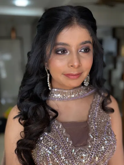 A soft and sultry look for an evening event. The makeup features a brown smokey eye and a nude lip, perfect for her embellished outfit.