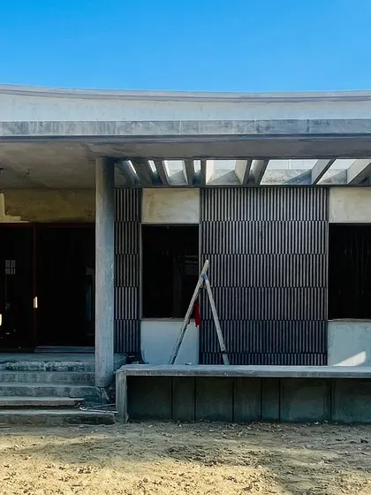 A single-storied residence in Palladam showcasing Neo-vernacular design. The facade features concrete fluted panels and a traditional 'Thinnai' (veranda), blending modern minimalism with Tamil traditions.