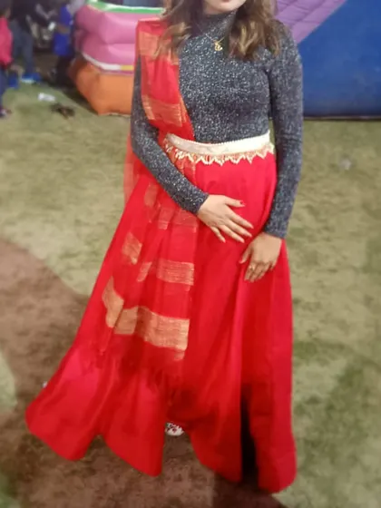 A full-length shot of the client in the red skirt, showing how the dupatta is draped to complete the indo-western look. A great rental option for a fun, festive occasion.