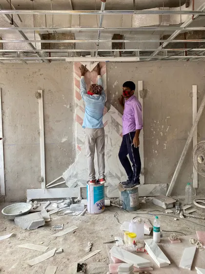 Craftsmanship in action. This image captures artisans meticulously installing an intricate marble inlay pattern on a wall. It's this attention to detail and skilled execution that brings our designs to life.