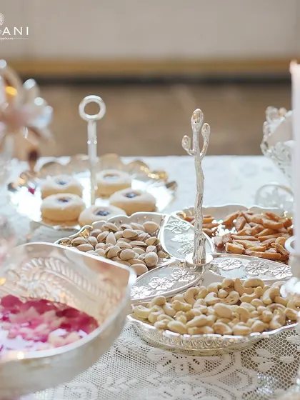 A festive table set for Diwali, featuring a multi-part silver serving dish for nuts and snacks. The cactus-shaped divider adds a unique, modern touch to a traditional item, blending style with functionality.
