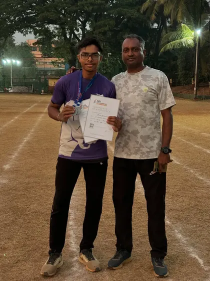 An athlete with his coach after winning silver medals in the 100m and 200m sprints at the SFA championships.