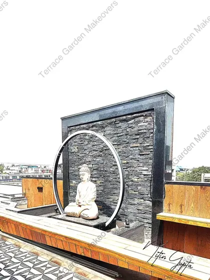 I designed this terrace to be a complete sensory experience. The centerpiece is a custom water feature with a meditating Buddha statue, framed by a modern circular light. The design is tied together with a stacked slate wall and integrated wooden bench seating.