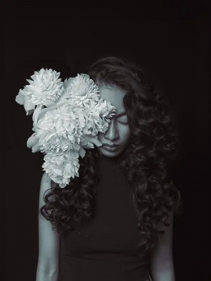 A soft and poetic black and white portrait. The use of flowers adds a natural, organic element to this fashion-forward shot, with the focus on texture and emotion.