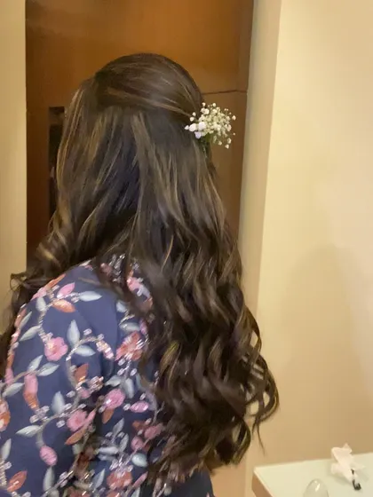 A side view of the soft curls and floral accessory, showing how it beautifully frames the face.