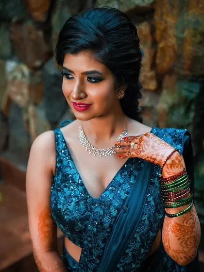 The bride gently touching her necklace, a classic pose that draws attention to both the jewelry and her elegant neckline.