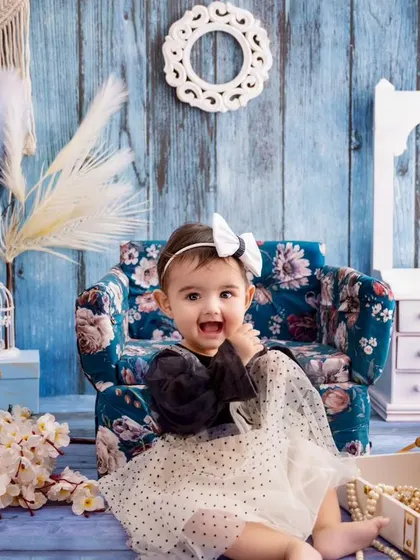 Catching the magic of toddlerhood, this little girl's happy expression is the highlight of this blue-themed portrait.