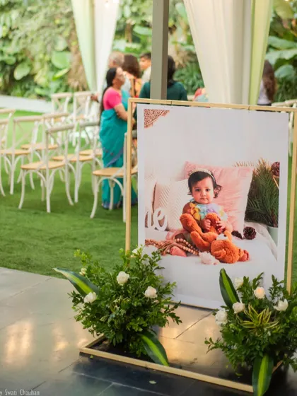 A beautifully framed photo of the birthday girl greets guests as they arrive. This personal touch, surrounded by simple floral arrangements, adds a touch of elegance to the party entrance.