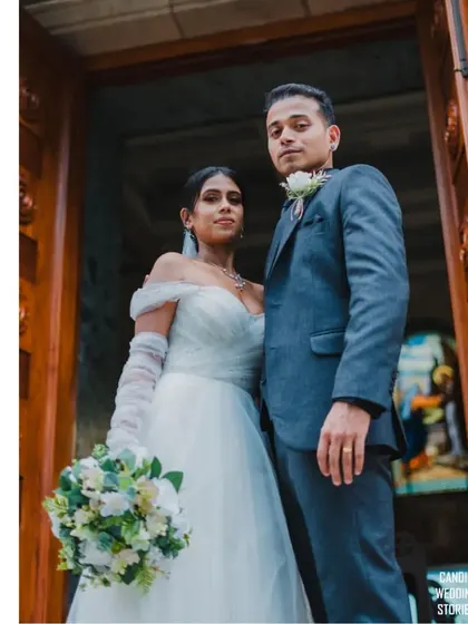 A powerful, low-angle shot of the bride and groom standing at the church entrance, looking confident and ready for their future together.