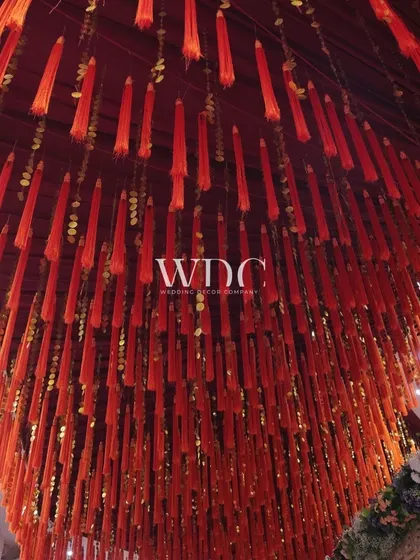 A close-up of the ceiling decor, featuring a dense canopy of red tassels, adding a vibrant and traditional touch to the Navratri celebrations.