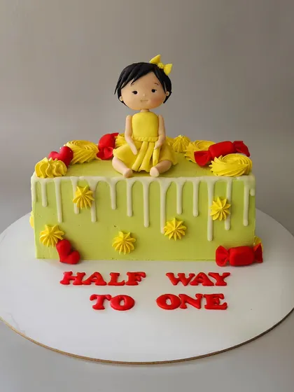 Miss V's half birthday cake! This chocolate truffle cake celebrates her being halfway to one with a cute figurine and a fun, colorful design.