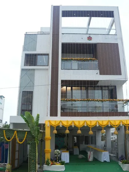 The exterior of a beautiful new home, decorated for a housewarming ceremony. The traditional yellow garlands at the entrance create a festive and welcoming look for this major life milestone.