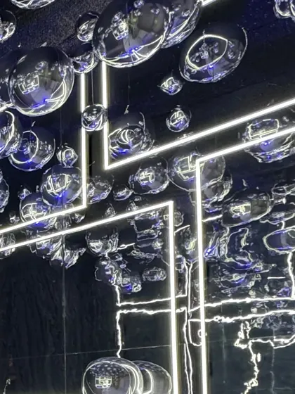 A ceiling of silver disco balls and neon light strips. This installation transformed the entire venue into a futuristic, high-energy dance club.