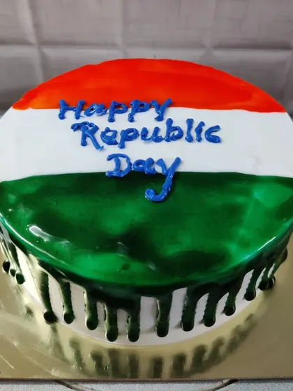 A Republic Day drip cake with a glossy glaze in saffron, white, and green.