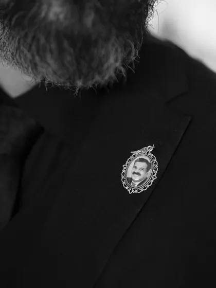 A touching detail on the groom's lapel. A small, framed photo of a loved one is a beautiful way to keep family close and honor their memory on the wedding day.