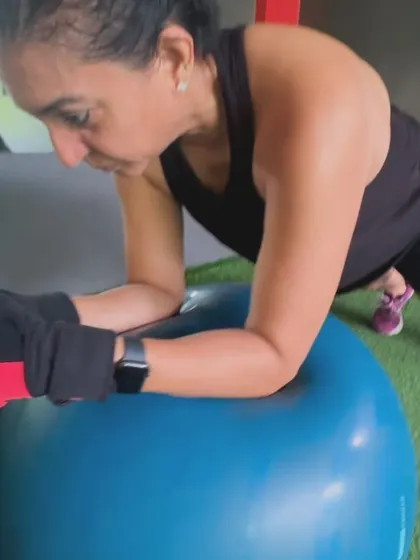 A client holds a plank on a stability ball, a challenging variation that requires significant core control to maintain balance.